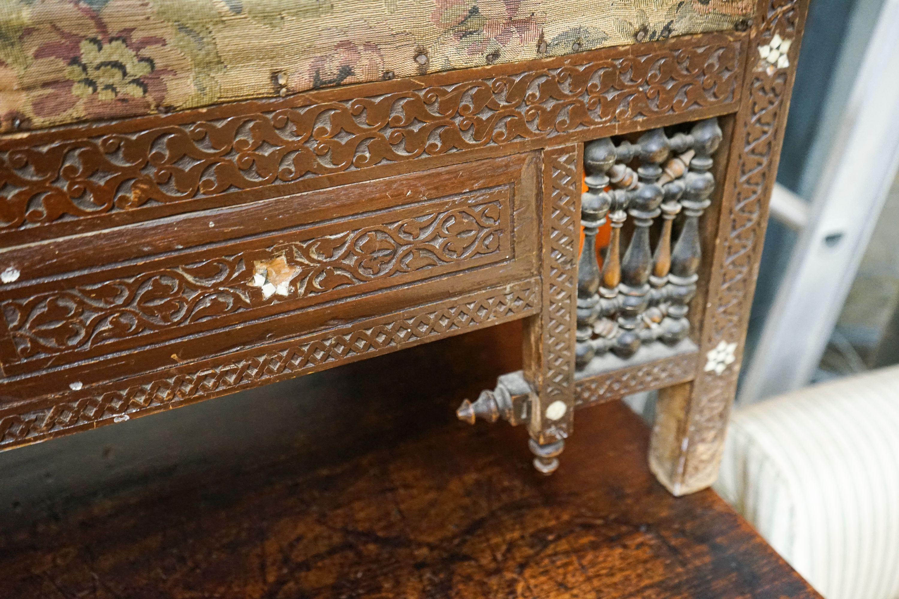 An early 20th century Moorish mother of pearl inlaid carved hardwood window seat, length 134cm, depth 44cm, height 64cm